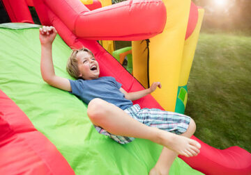 Boy Sliding Down an Inflatable Bounce Castle